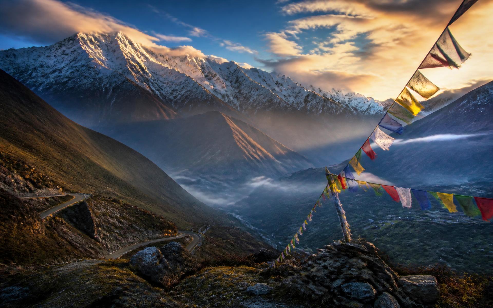 Sunrise over a Himalayan valley with prayer flags in India